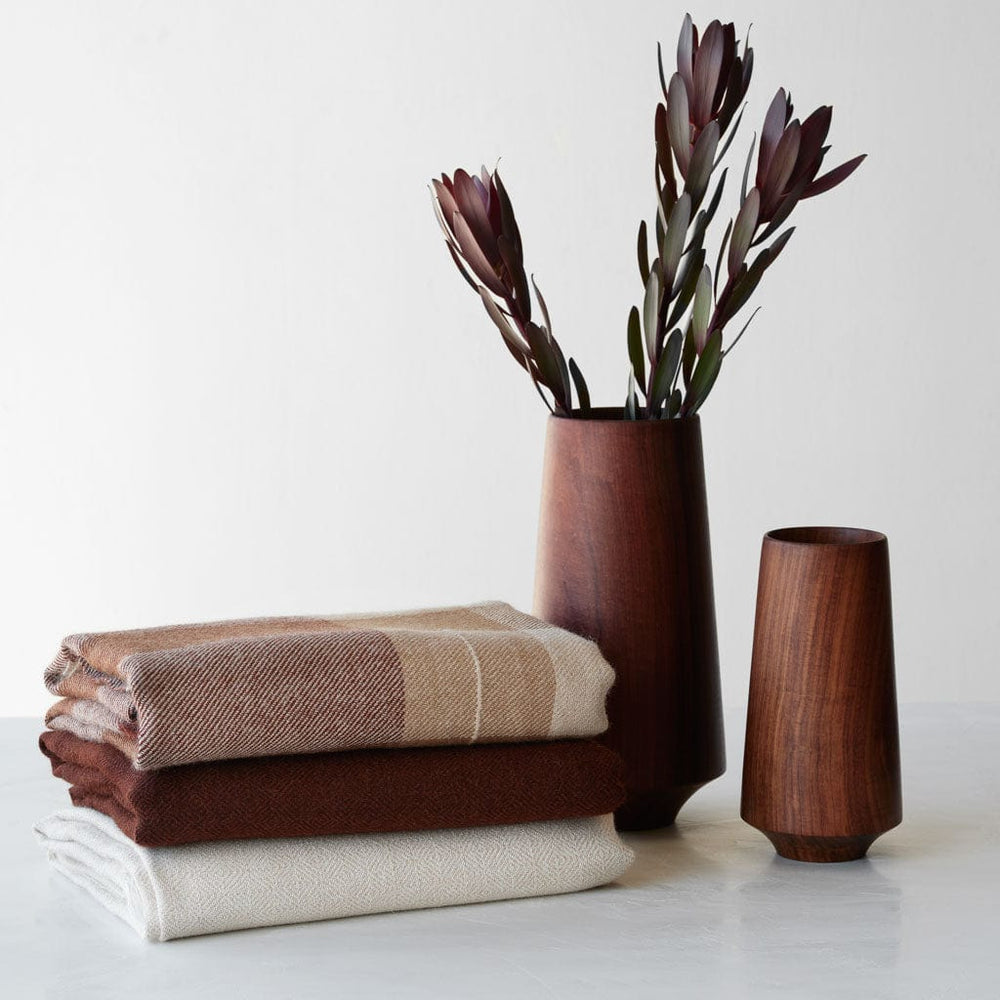Alpaca throw styled with wood vase, tan and rust