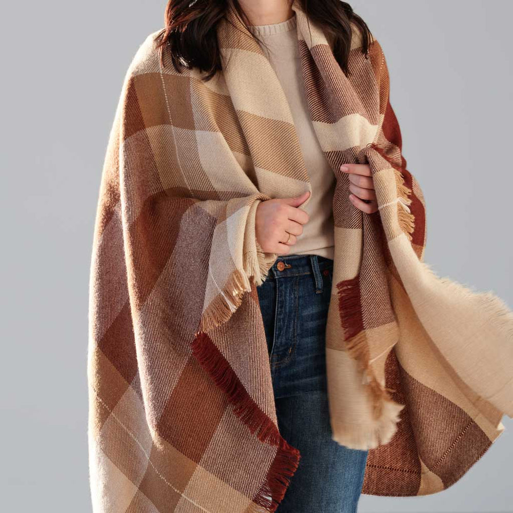 Model holding alpaca throw with fringe, tan and rust