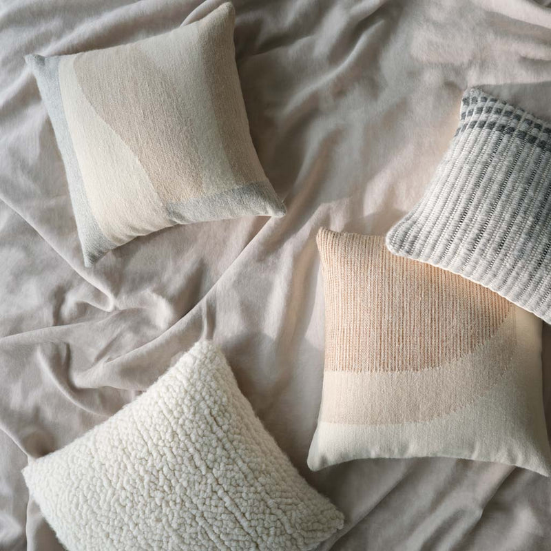 Overhead of wool and alpaca pillows, ivory