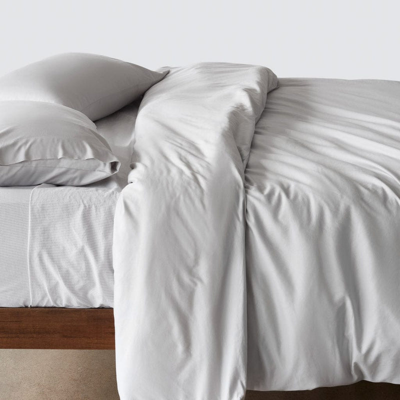 Side of bed with duvet and pillows, solid-light-grey