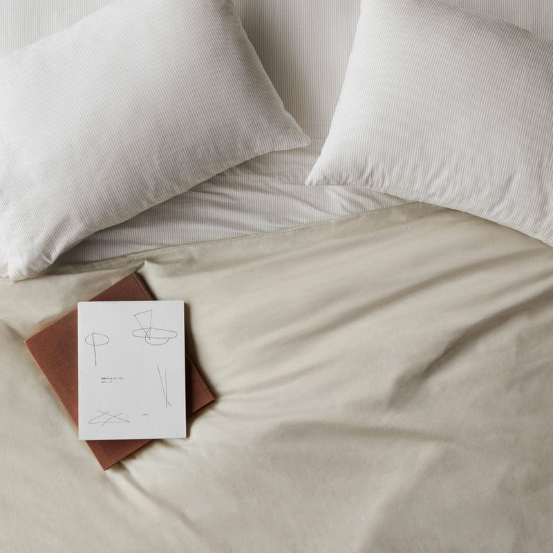 Book lying on top of duvet cover, solid-sand