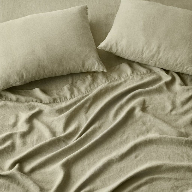 Overhead of sage green linen sheet set and pillows, sage