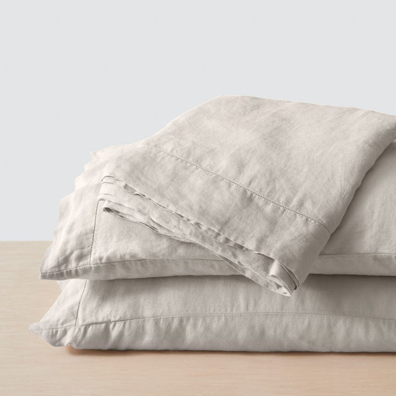 Stack of two linen pillows and sheet, solid-sand