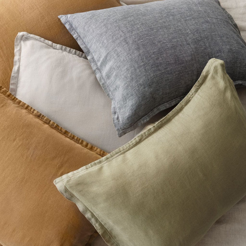 Pile of various colored linen pillows, solid-sand