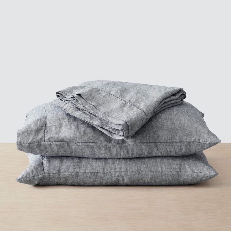 Top sheet folded on stack of two pillows, indigo-chambray