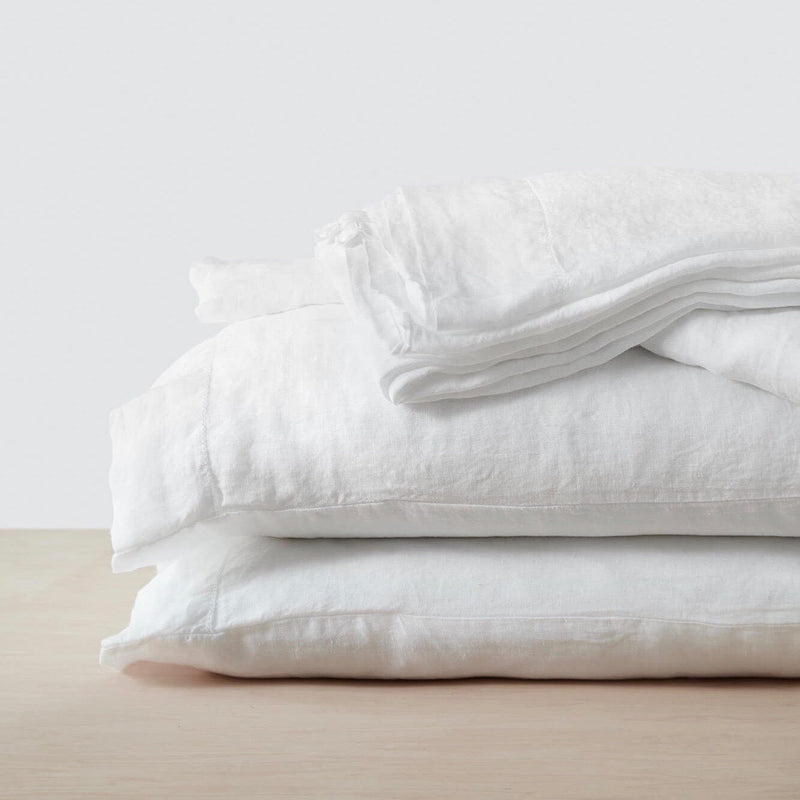 stack of white linen bedding, white