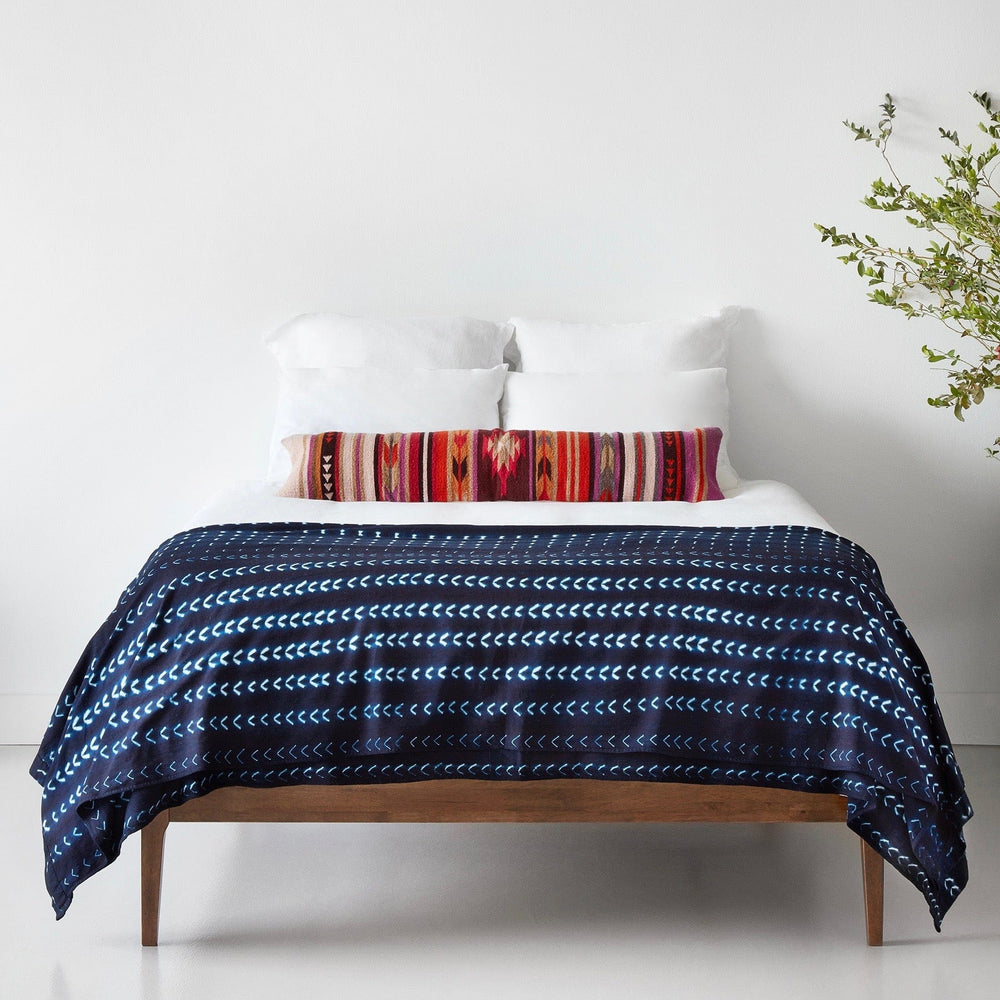 Geometric and striped oversized lumbar pillow styled with bed blanket, multicolor