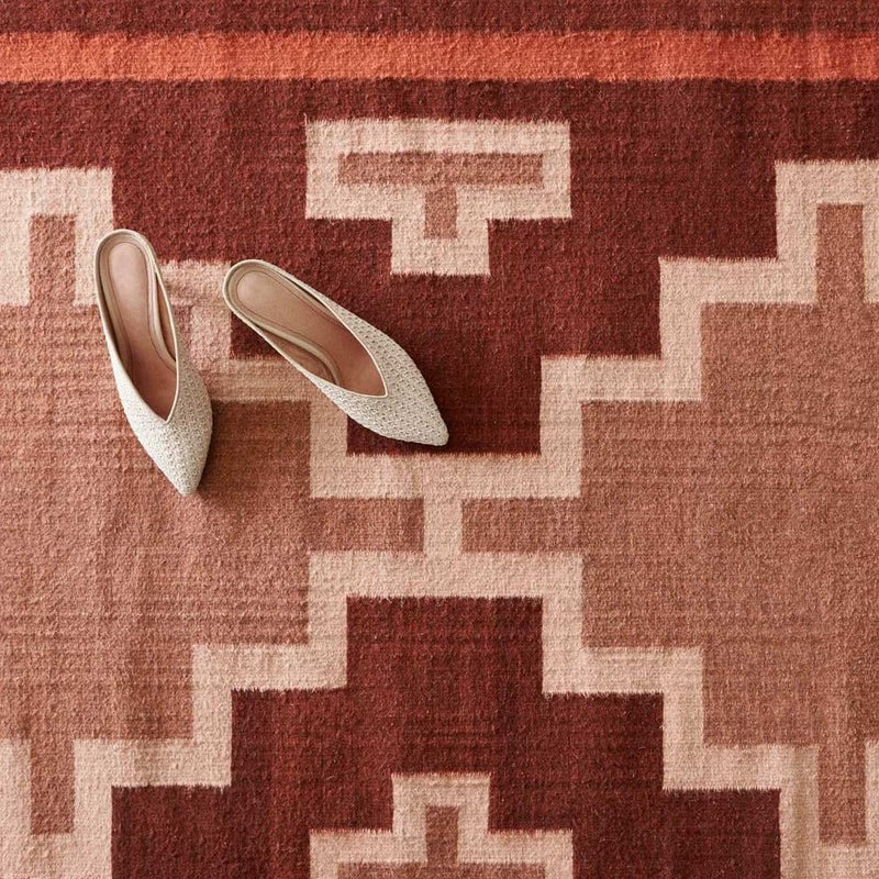 Handwoven Wool Area Rug in Warm Red Hues Styled with Shoes, sienna