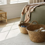 Alpaca throw on bed with woven baskets, tan