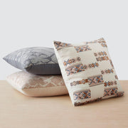 Geometric pillow styled with more pillows, cream and blue and peach