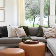 Geometric pillow styled on grey couch, cream and blue and peach