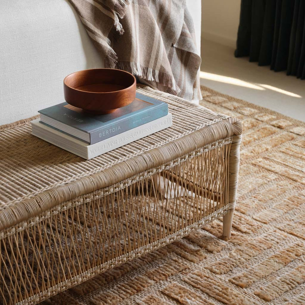 Woven Bench styled with books and bowl, rattan