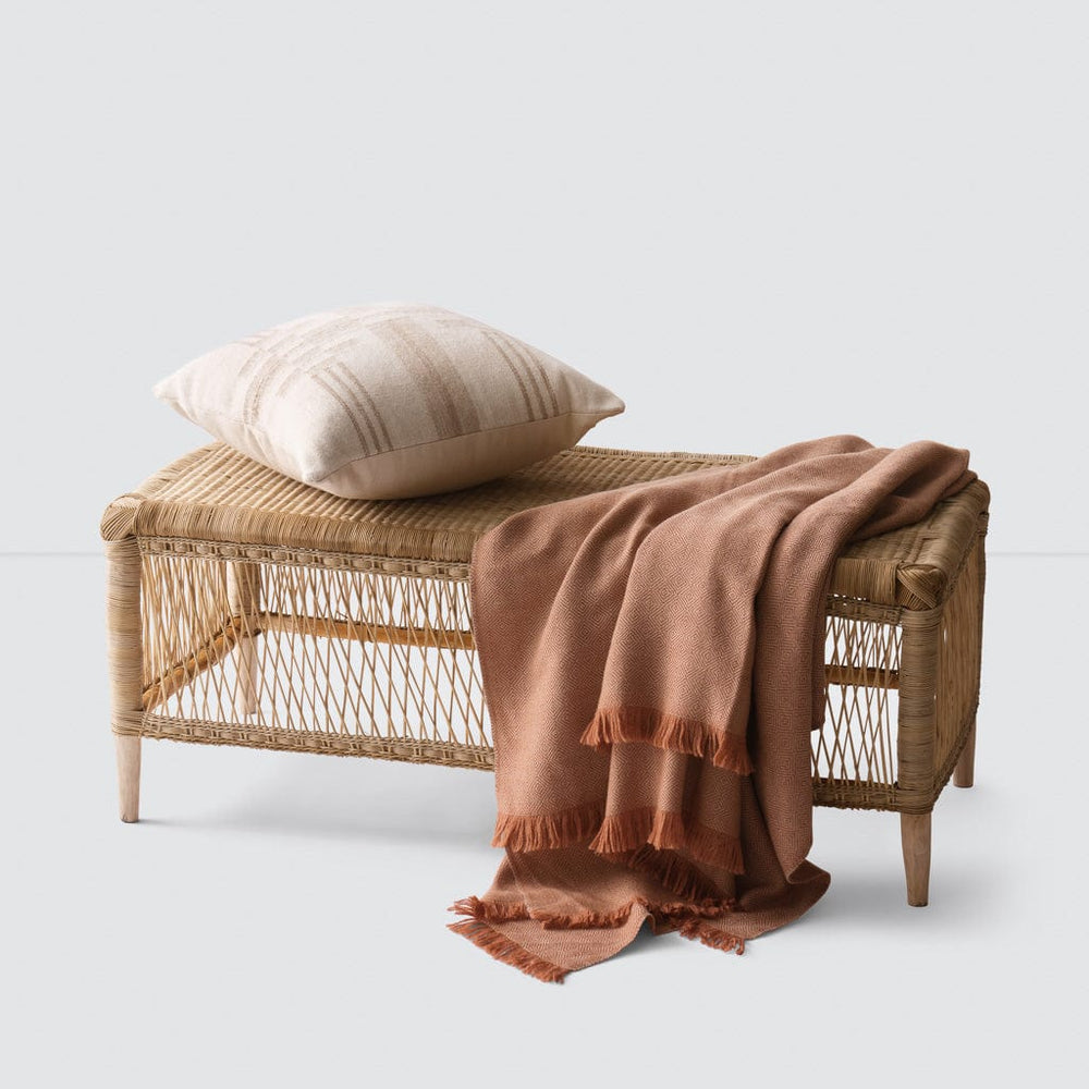 Woven Bench styled with blanket and throw pillow, rattan