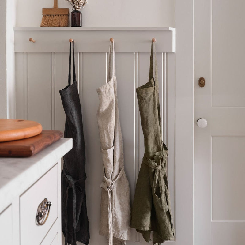Styled shot of linen aprons hanging, charcoal