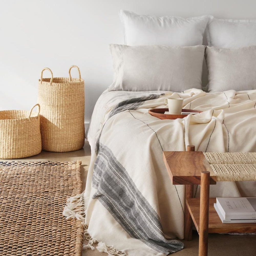 Pair of Handwoven Baskets in Natural Materials styled with bed