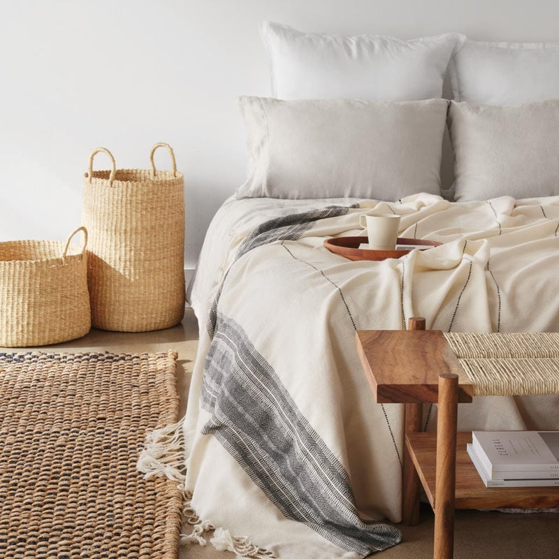 Pair of Handwoven Baskets in Natural Materials styled with bed, natural