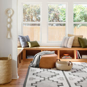 Handwoven Basket in Natural Materials styled in room with leather ottoman, natural