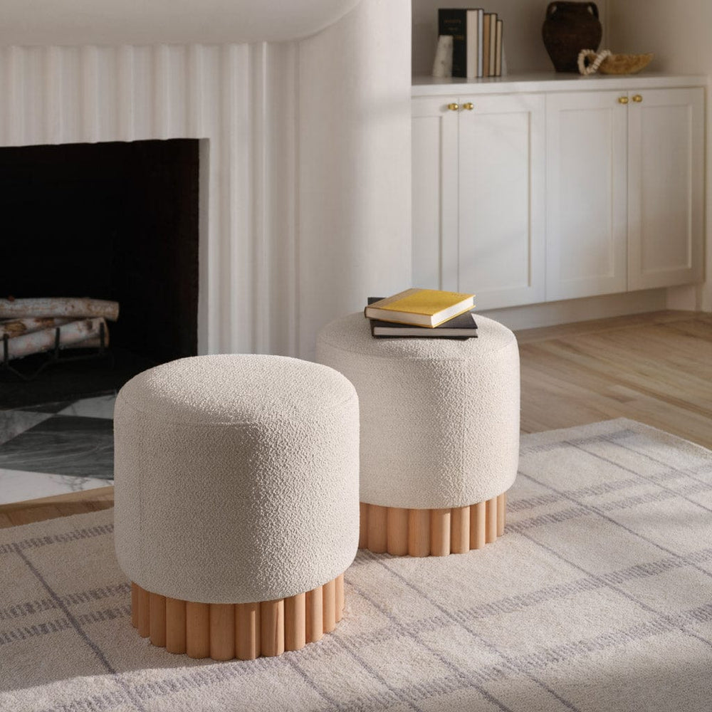 Pair of boucle ottomans in front of fireplace