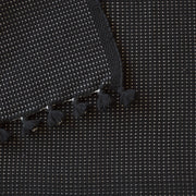 Close up of black bath mat highlighting stitching and fringe, black