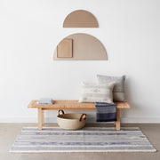 Two bronze half moon mirrors (large and small) hanging over table