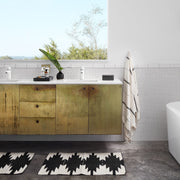 Striped towel hanging next to bathroom vanity, ivory