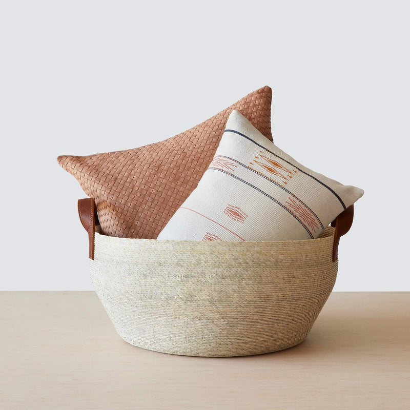 Medium handwoven palm storage basket with pillows inside, natural
