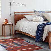 teak wooden side table by bed