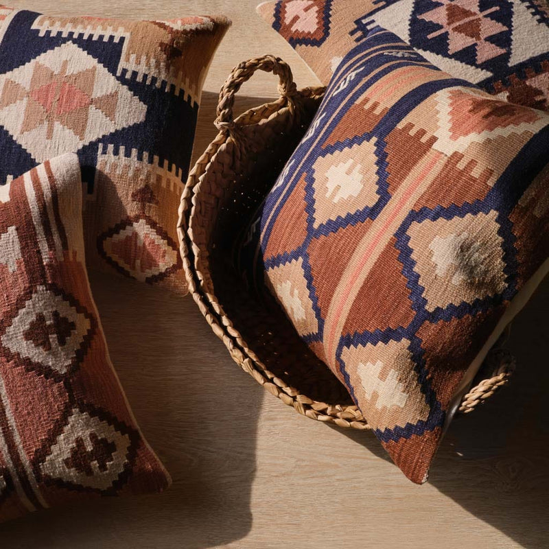 Overhead of kilim pillows styled in chunky woven baskets,navy