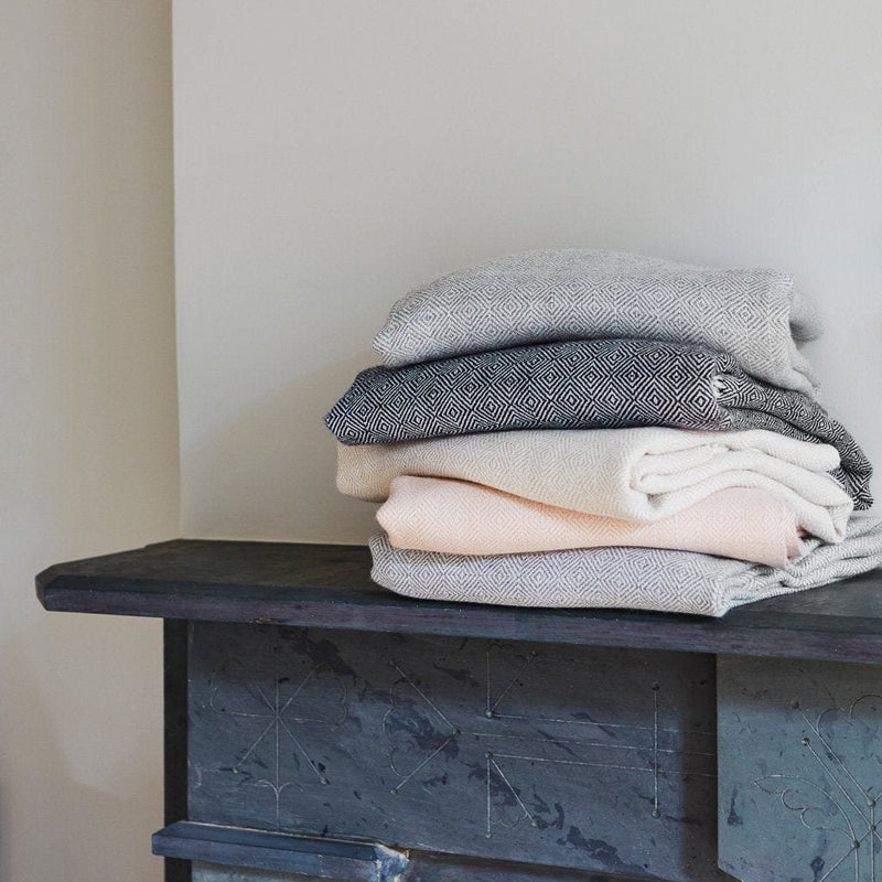 stack of alpaca blankets on shelf, dove-grey