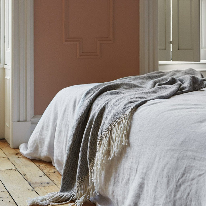 alpaca throw draped over bed, dove-grey