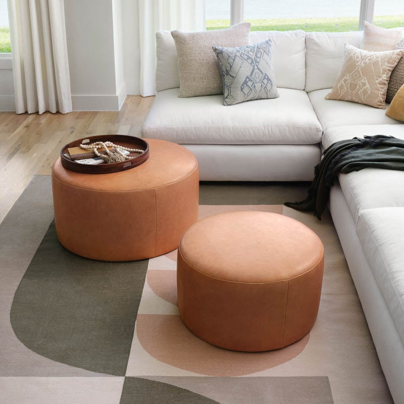 Tan leather round ottomans styled on top of abstract olive area rug, olive
