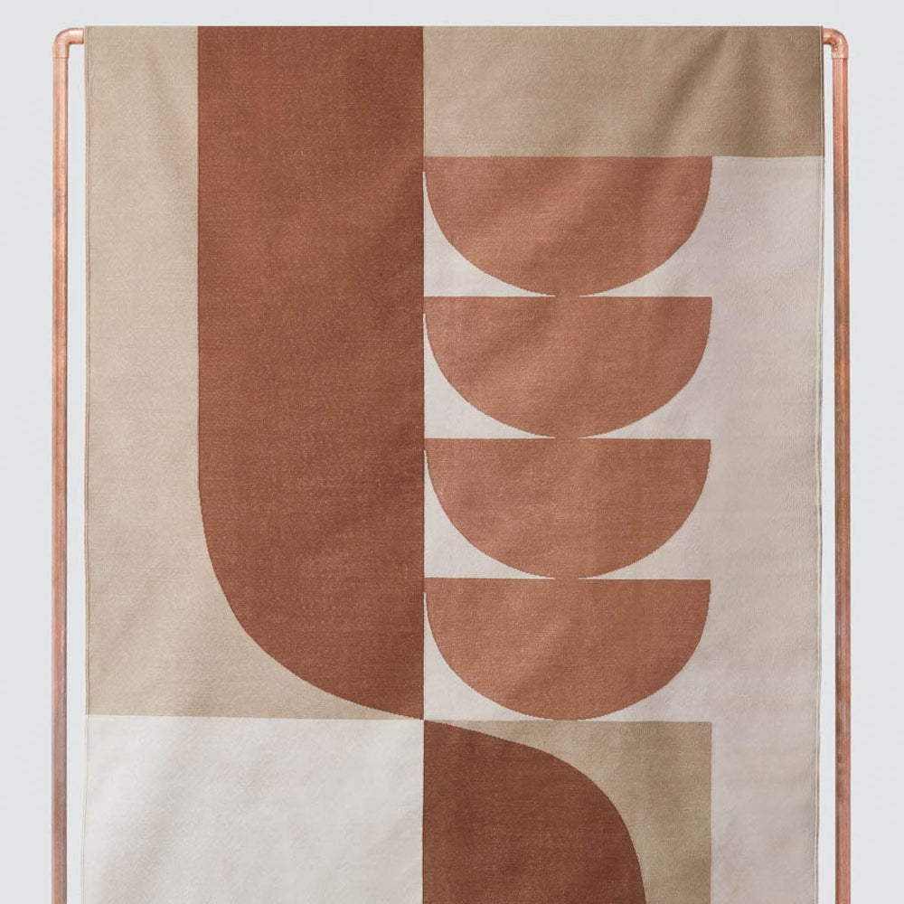 Abstract woven area rug in rust and tan hues, rust
