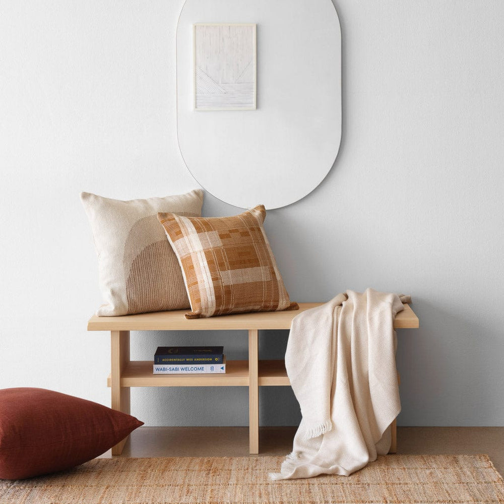 Hinoki wood bench styled in an entryway with throw pillows and jute rug