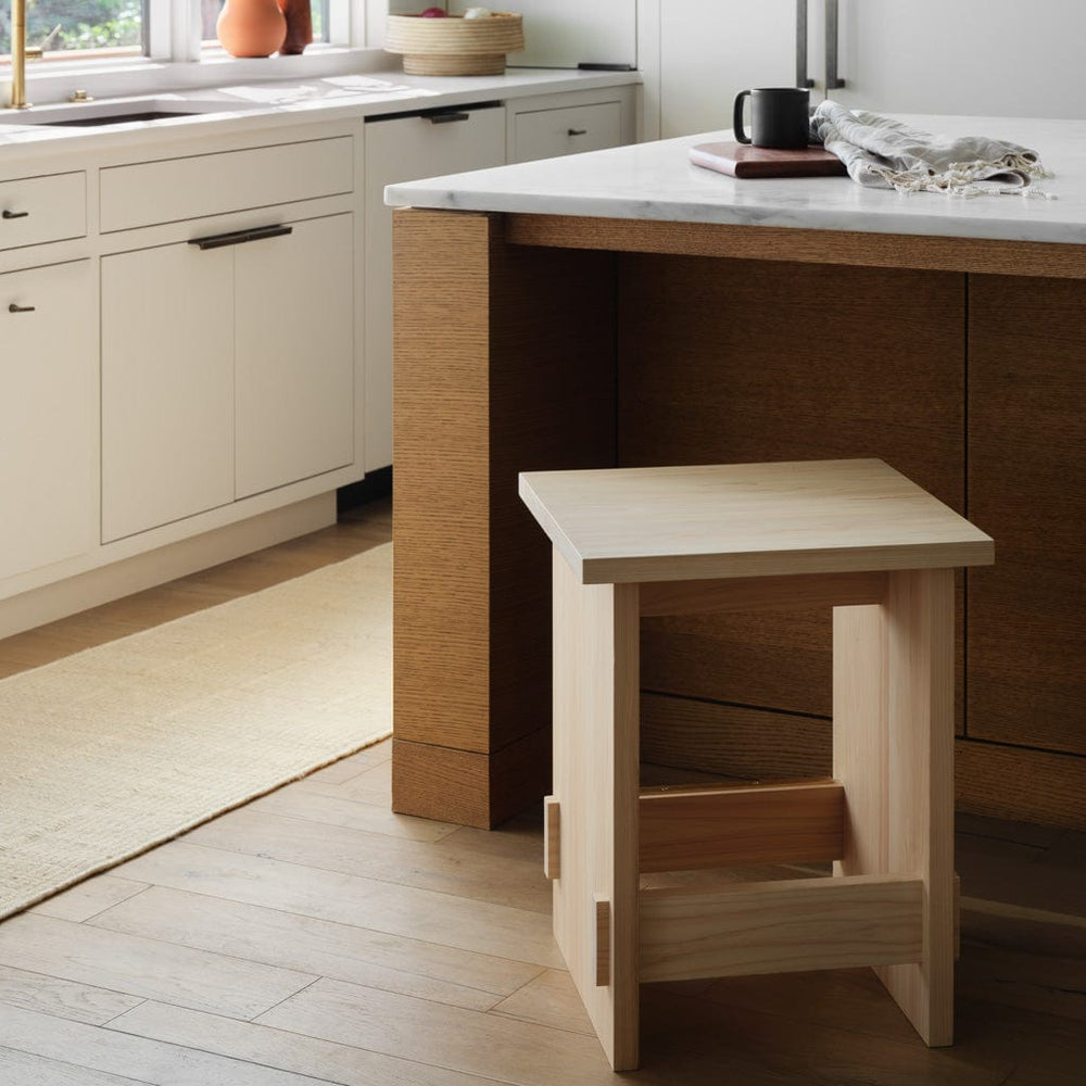 Hinoki counter stool pulled out from island in modern kitchen