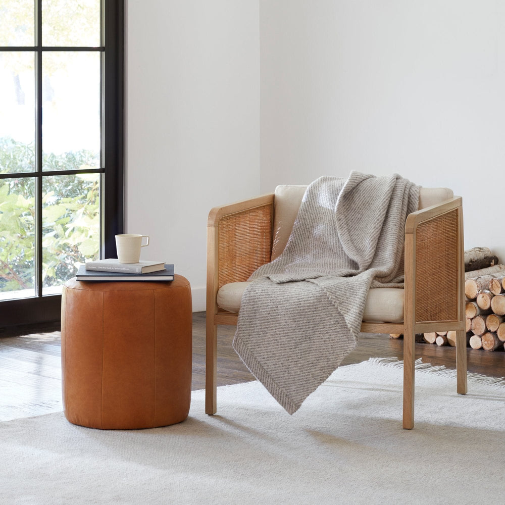 Luxe Wool Rug with Cane Chair and Leather Pouf