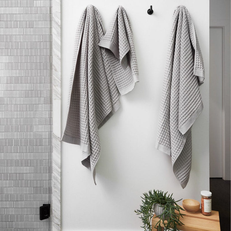 Waffle towels hanging from bath hooks, light-grey