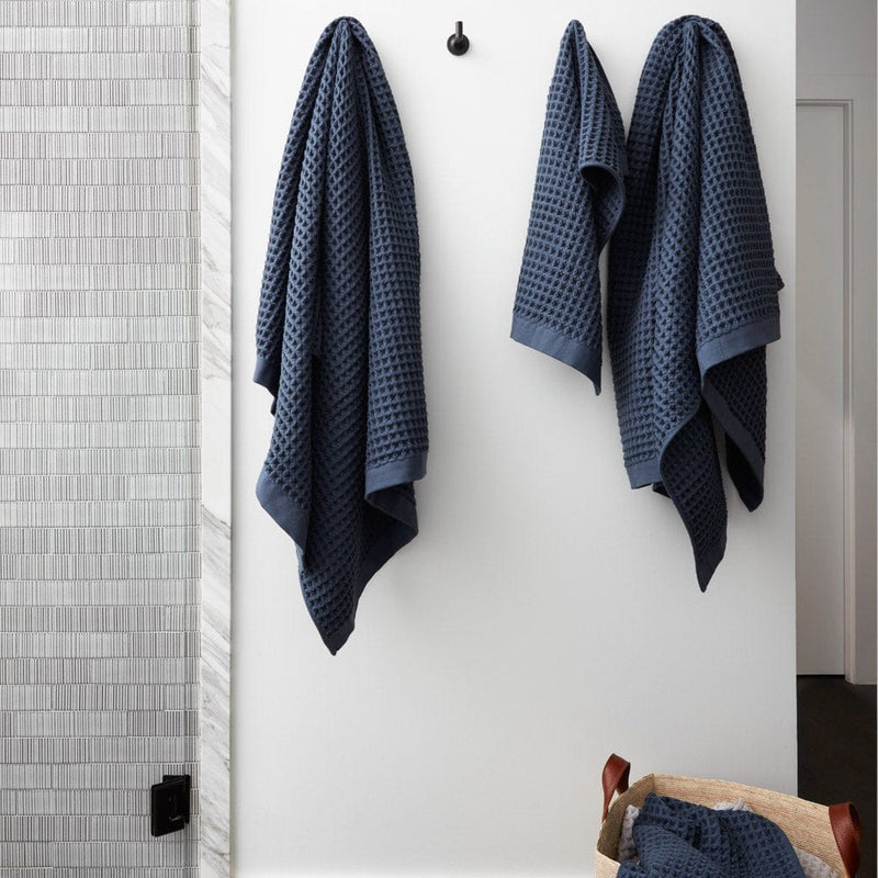 Waffle towels hanging from bath hooks, indigo