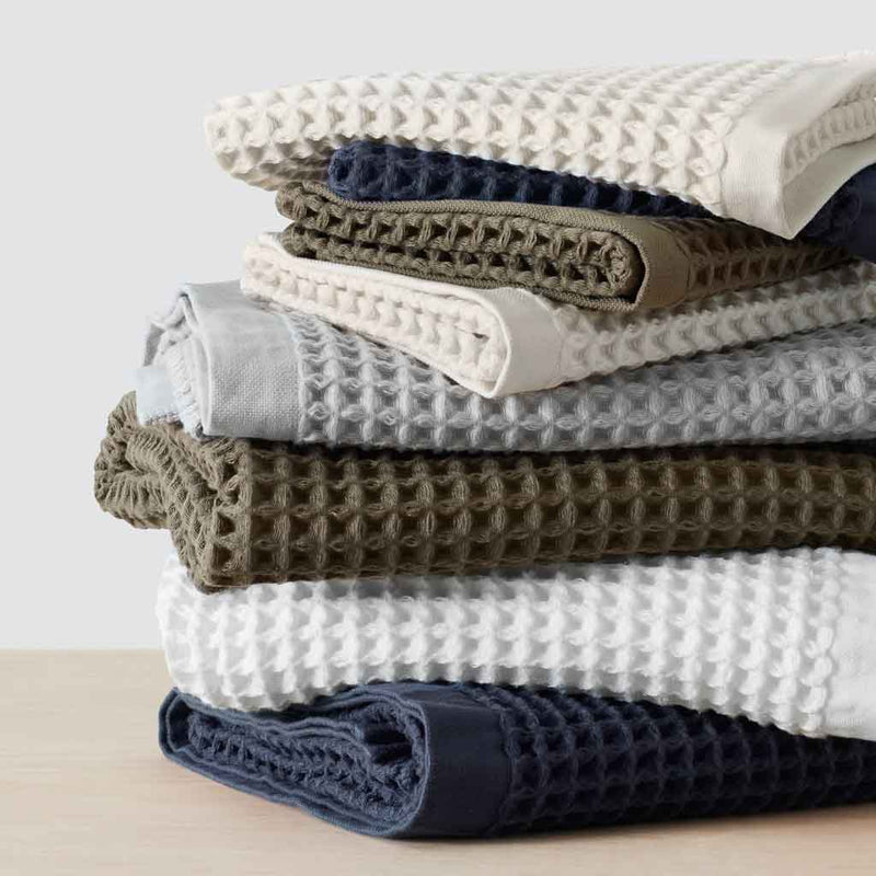 Stack of folded waffle towels, olive