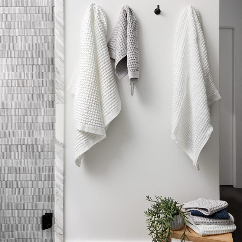 Waffle towels hanging from bath hooks, white