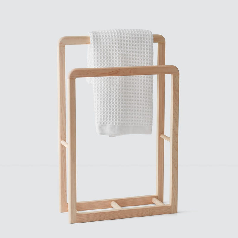 Waffle towel hanging from wood rack, white