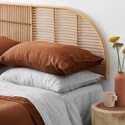 Closeup of rattan headboard and stonewashed linen bedding