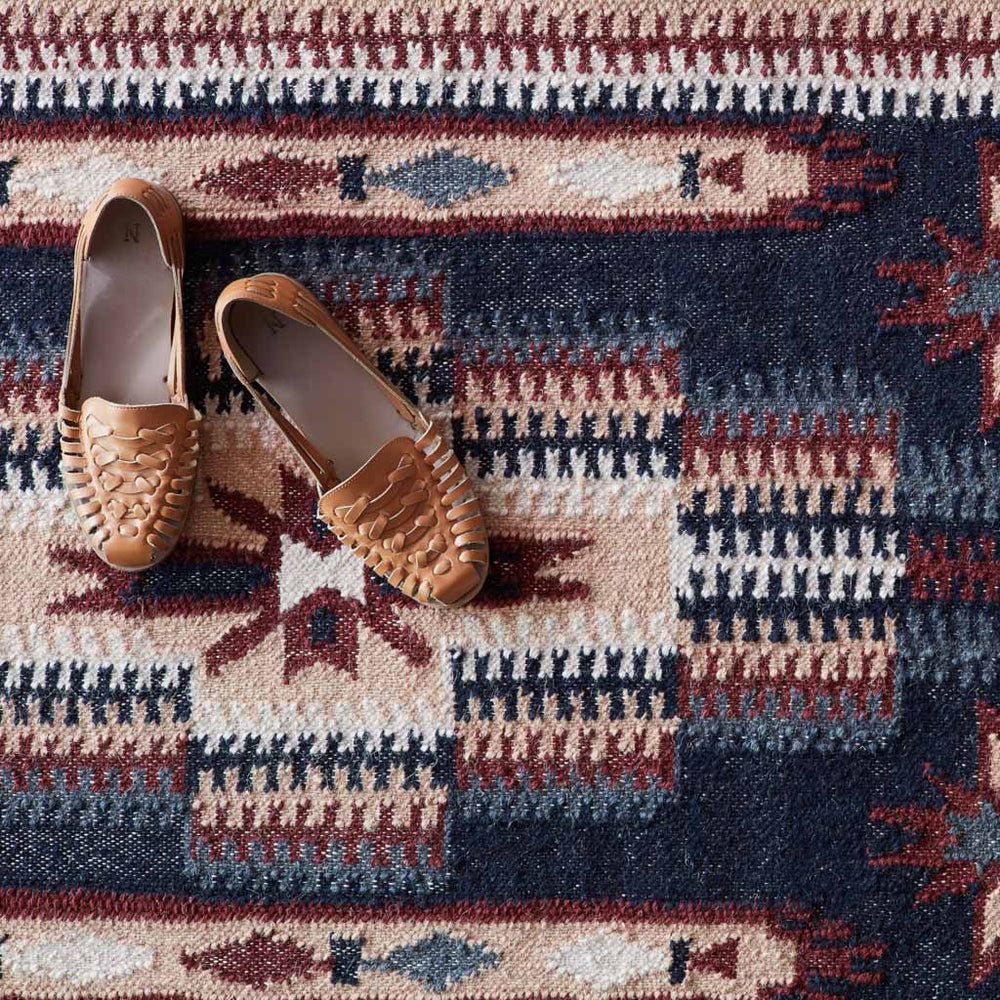 Overhead of Intricate Kilim Rug in Marrom and Navy with Brown Shoes