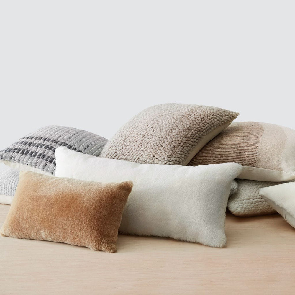 Pile of sheepskin and alpaca pillows, stone