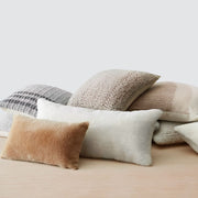 Pile of sheepskin and alpaca pillows, stone