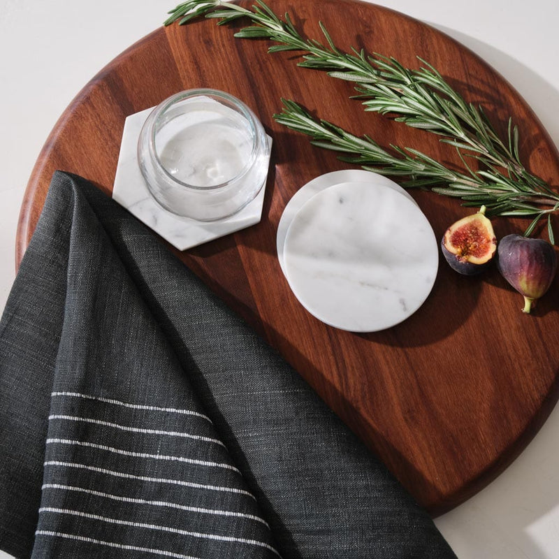 Overhead shot of coasters with serving board and napkin, white-marble