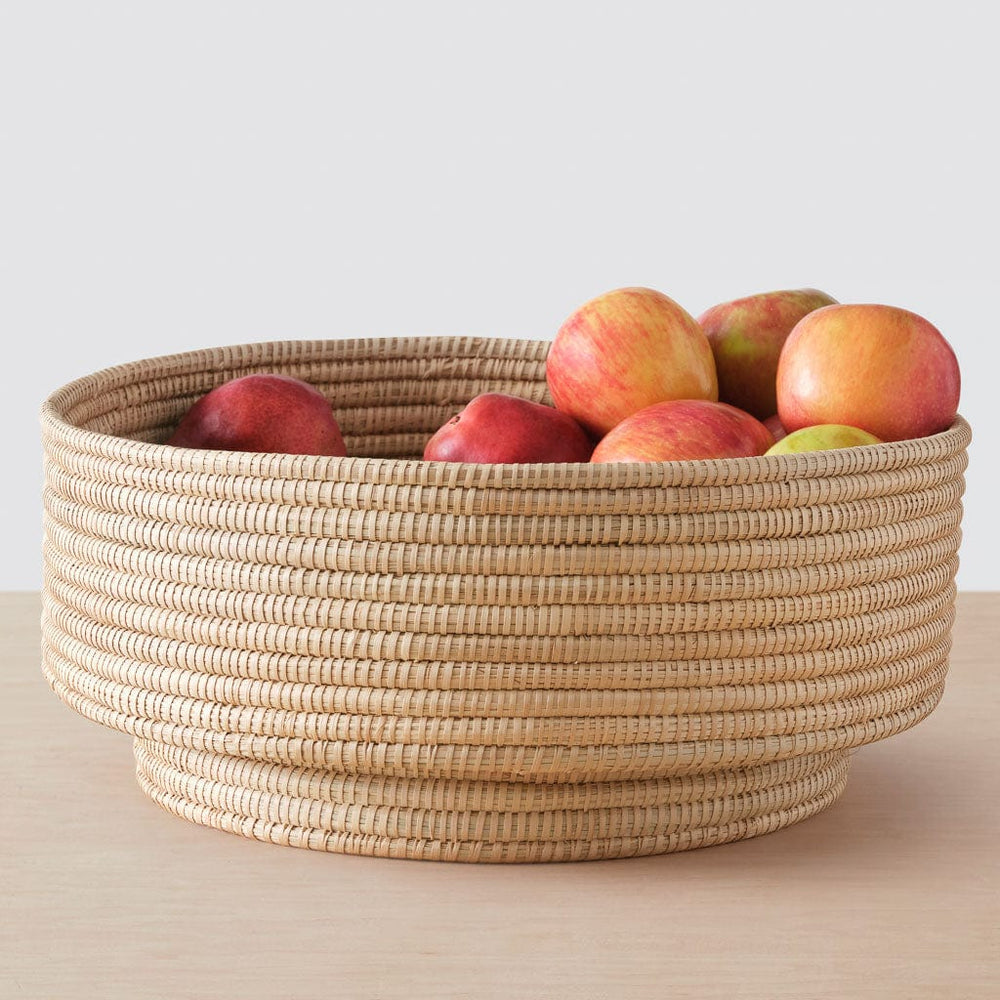 Apples on oversized woven palm bowl