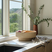 Woven bowl styled by window in kitchen
