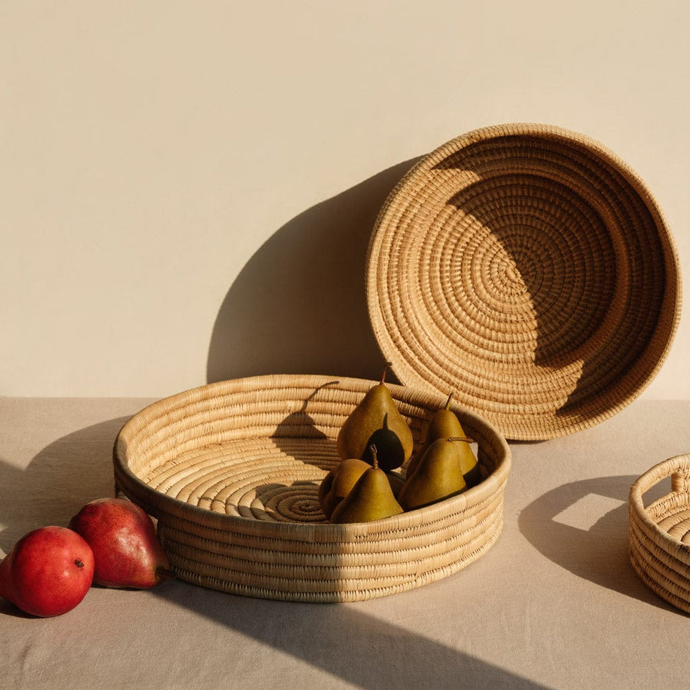 Various fruits in woven palm bowl and tray