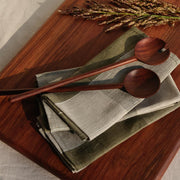 Wooden salad servers on napkins, olive