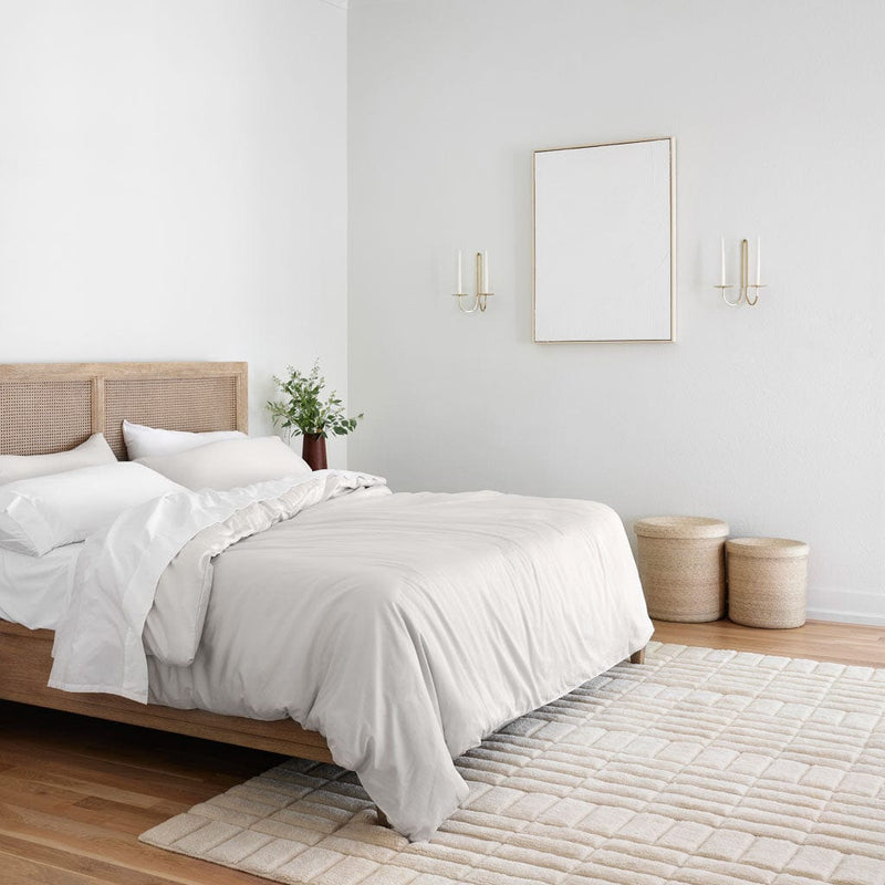 Modern bedroom with area rug and woven baskets, solid-light-grey